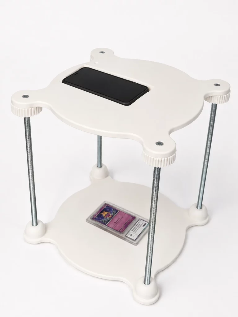 Dispositif de prise de photo imprimé en 3D avec plateaux blancs, tiges filetées et support central.