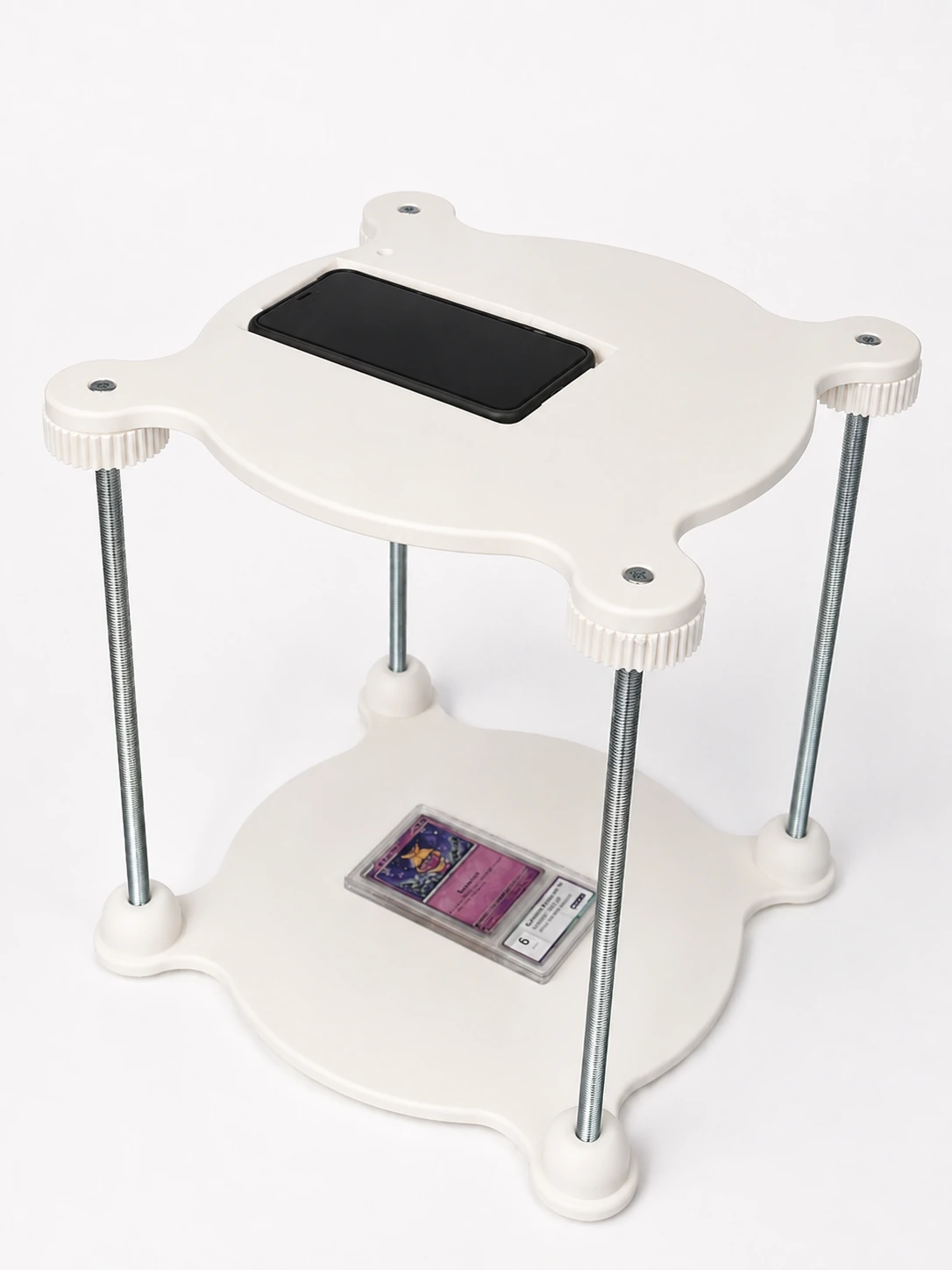 Dispositif de prise de photo imprimé en 3D avec plateaux blancs, tiges filetées et support central.
