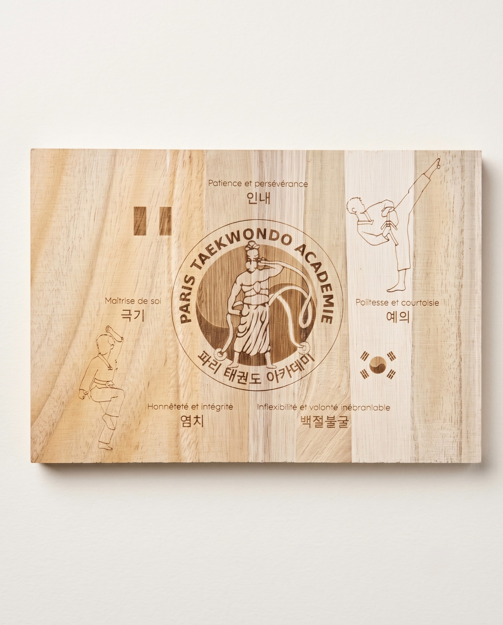 Planche en bois gravée au laser avec visuels et texte personnalisés pour la Paris Taekwondo Académie.