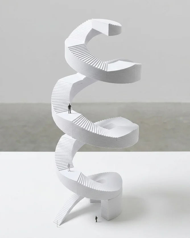 Maquette blanche d’un escalier en spirale imprimée en 3D, sur plusieurs niveaux, avec de petites figurines.